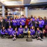 GarfiGarfield High Girls Basketball teams smiles at camera with state trophy.